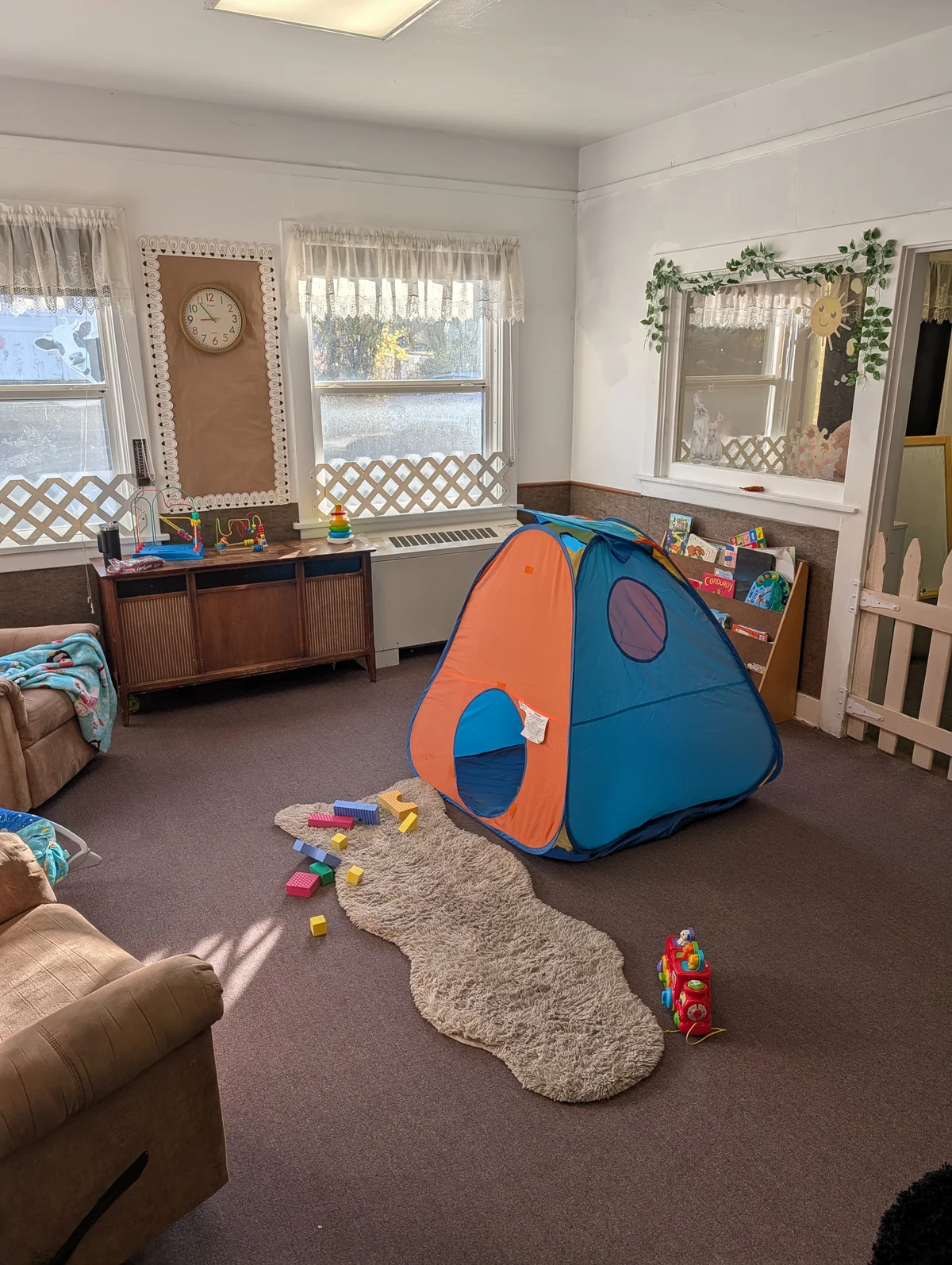 Kindergarten readiness discovery room with sunny reading tent, books and play rug